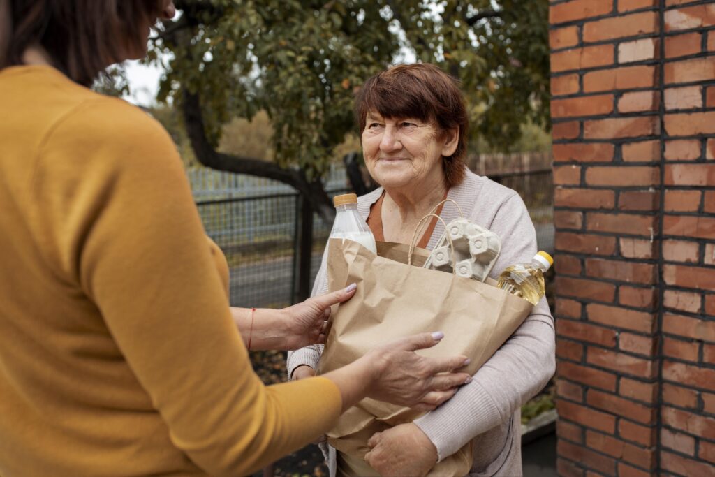 Nonprofit volunteer helping a senior, demonstrating how can senior citizens get free money through charities.