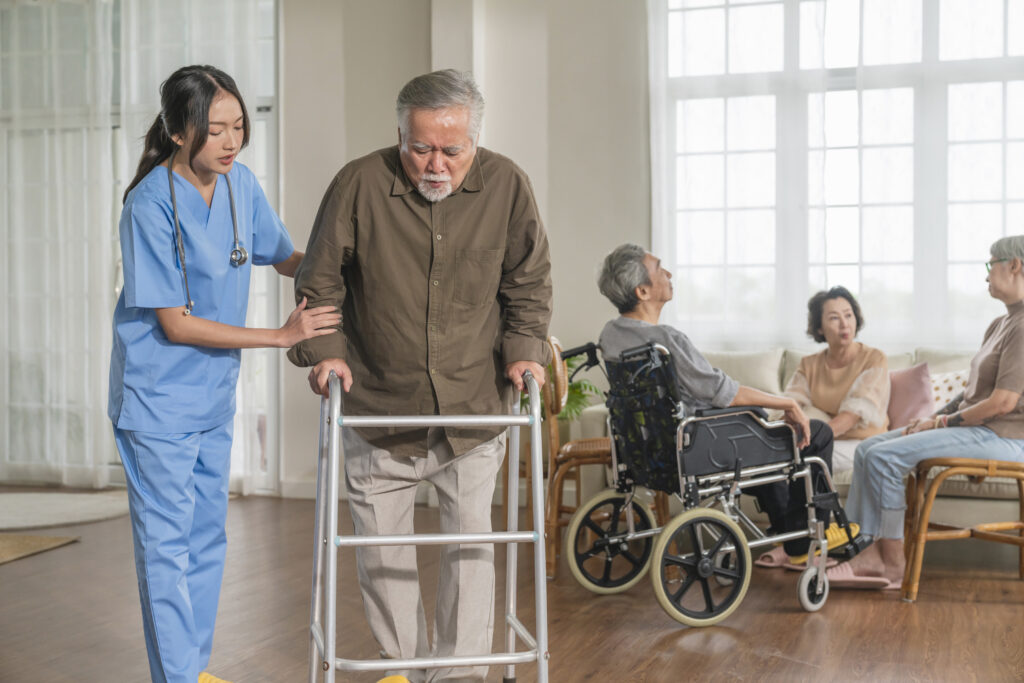 Elderly person using walker for mobility support in help for elderly in home.